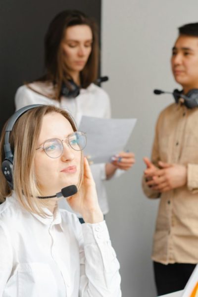Call centre agents on customer calls with headsets and discussing follow up actions